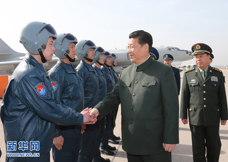 2015年2月16日，習近平同空軍航空兵某團飛行機組和機務人員握手交談。李剛攝